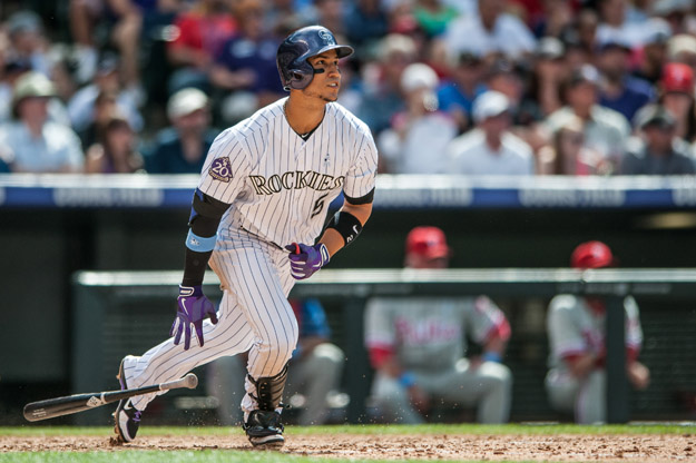 DENVER, CO - JUNE 16: Carlos Gonzalez #5 of the Colorado Rockies watches the flight of a two-run eighth inning home run against the Philadelphia Phillies at Coors Field on June 16, 2013 in Denver, Colorado. The Rockies beat the Phillies 5-2. 