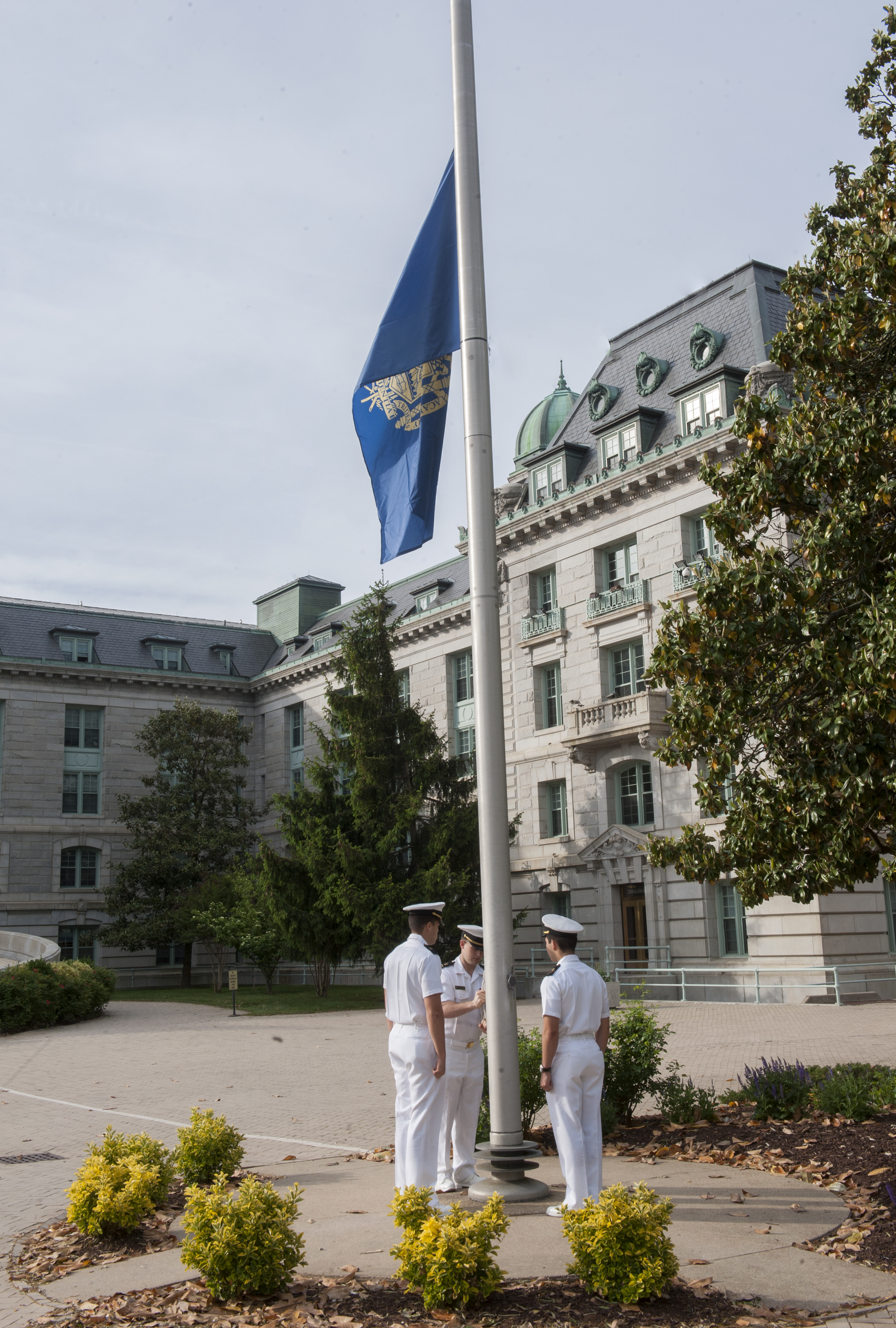 ANNAPOLIS, Md. (May 15, 2015) U.S. Naval Academy midshipman lower the Naval Academy flag to half-staff in remembrance of Midshipman Third Class Justin B. Zemser during morning colors at Tecumseh Court May 15. Zemser was one of the passengers who lost their life due to injuries sustained in the AMTRAK train crash in north Philadelphia May 12. (U.S. Navy photo by Mass Communication Specialist 3rd Class Nathan Wilkes /Released)