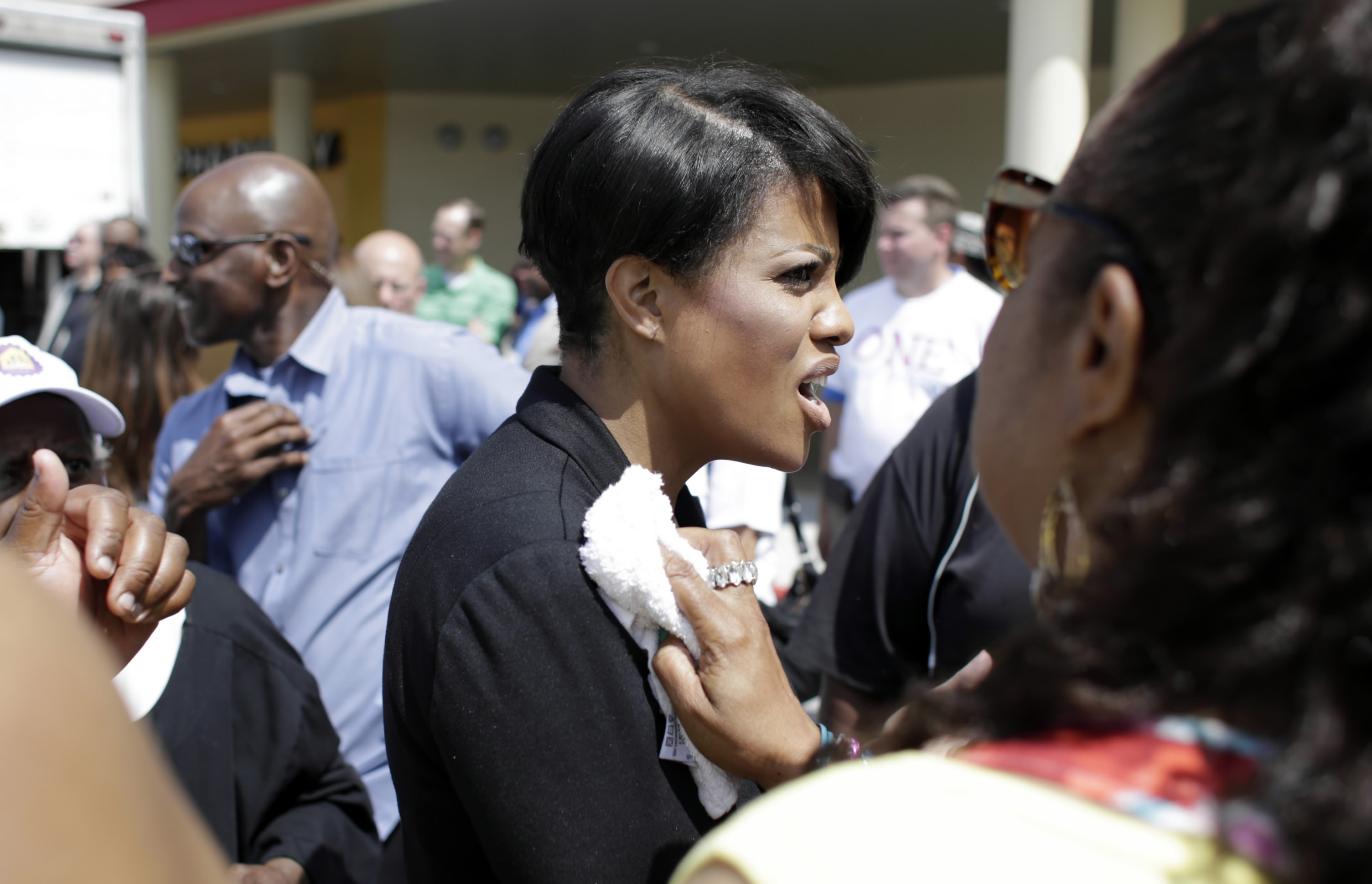 Baltimore, MD - 07/11/15 - Mayor Stephanie Rawlings-Blake has water dumped on her by a bystander after speaking at the Mondawmin mall Tom Brenner / The Baltimore Sun. 