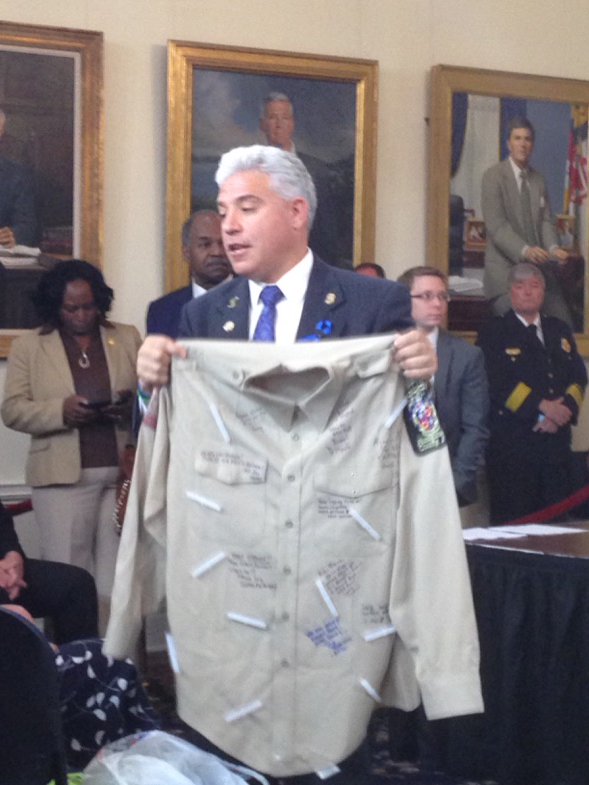 Noah's father Richard Leotta holds his son's uniform shirt signed by fellow officers. Photo/WJZ-TV